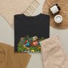 Black T-shirt with "In the Bushes Finding Myself" disc golf graphic, lifestyle flat-lay