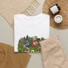 White T-shirt with "In the Bushes Finding Myself" disc golf graphic, lifestyle flat-lay