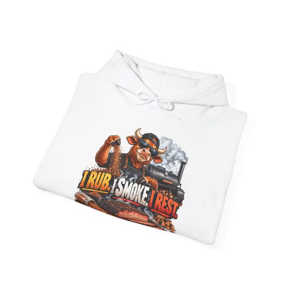 Folded white hoodie showing "I Rub. I Smoke. I Rest" BBQ graphic