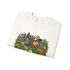Folded white crewneck sweatshirt showing "In the Bushes Finding Myself" disc golf graphic