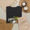 Black T-shirt with "I Hit a Tree and Called It Strategy" golf graphic, lifestyle flat-lay