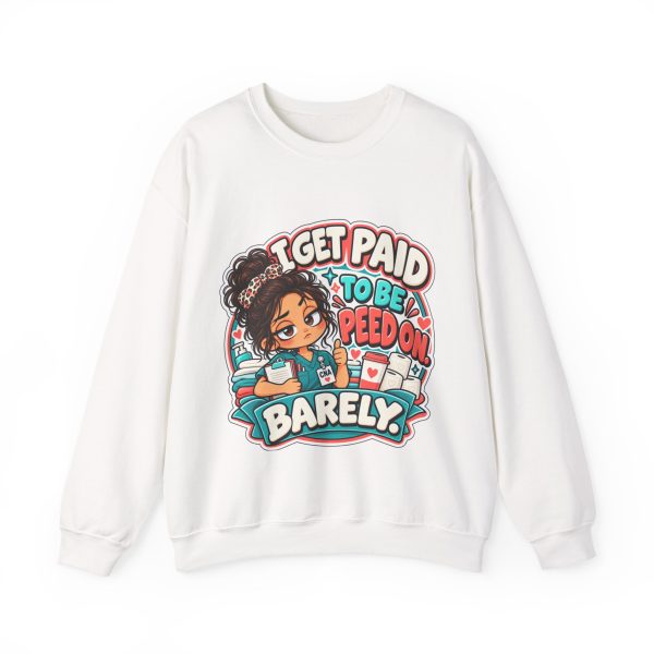 White crewneck sweatshirt printed with "I GET PAID TO BE PEED ON. BARELY." and a tired CNA in teal scrubs giving a thumbs-up
