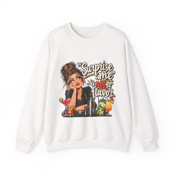 Front of the white unisex sweatshirt printed with an eye-rolling bartender in a black apron leaning on the bar behind a row of cocktails and a steel shaker and the words “Surprise me” is not a flavor.