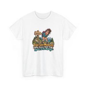 Front of the white unisex t-shirt printed with a worn-out hiker clutching her knees beside a wooden MODERATE trail sign, with pine trees and snowy mountains and the words "Trail Said Moderate. My Knees Want To Speak To The Manager."