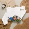 White crewneck sweatshirt with "Still Looking for That Fairway" golf graphic, lifestyle flat-lay