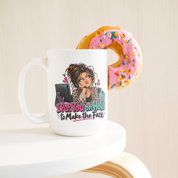I Put You on Hold to Make the Face. funny 15oz white coffee mug, on a table with a donut
