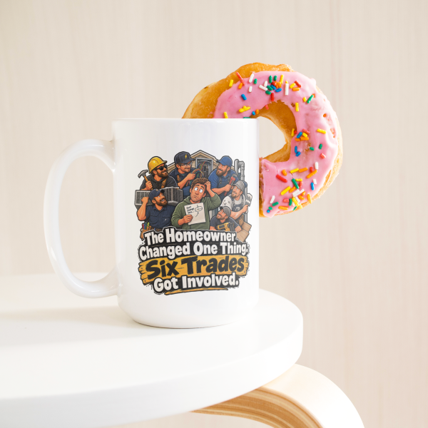 The Homeowner Changed One Thing. Six Trades Got Involved. 15oz mug - with a donut The Homeowner Changed One Thing. Six Trades Got Involved. funny 15oz white coffee mug, on a table with a donut