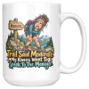 White 15oz ceramic mug with the handle on the right, showing a worn-out hiker clutching her knees beside a wooden MODERATE trail sign, with pine trees and snowy mountains and the words "Trail Said Moderate. My Knees Want To Speak To The Manager."