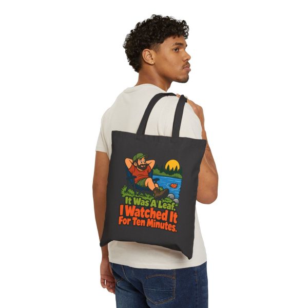 Birders. It was a leaf. I watched it for ten minutes. Tote - person-front Model carrying the tote on one shoulder, front print showing. Black flat vector tote bag with the birder joke: It was a leaf. I watched it for ten minutes.