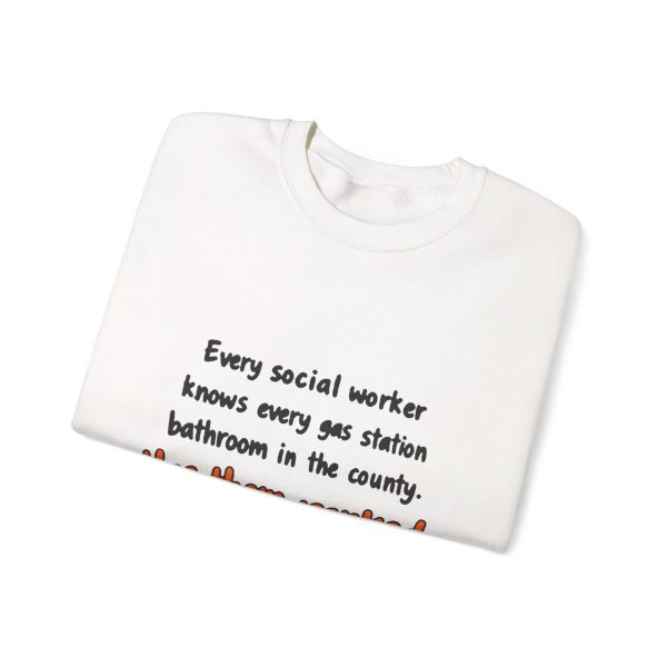 Gas station bathrooms ranked, and social work knows it. Marker crewneck White hand-drawn crewneck sweatshirt with the social work dictionary joke: Knows every gas station bathroom in the county. Has them ranked., folded view