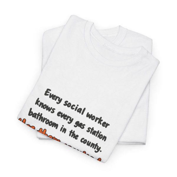 Has every gas station bathroom ranked. Yes, on a hand-drawn social work tee White hand-drawn T-shirt with the social work gas station bathroom ranking joke, folded view