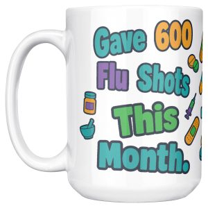 15 oz white ceramic pharmacist mug, "Gave 600 flu shots this month" on one side and "I still look away at mine" on the other, with pills, bandages and syringes, handle on the left, first side