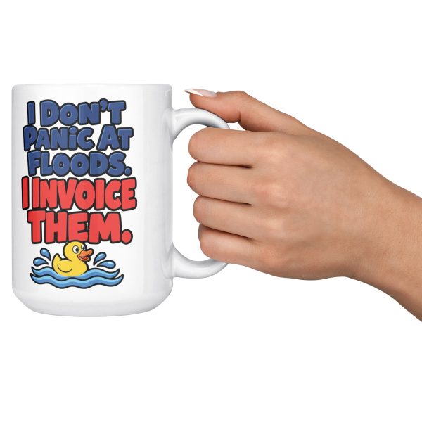 15 oz white ceramic plumber mug printed with "I Don't Panic At Floods. I Invoice Them.", held out by the handle