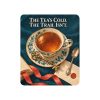 Tan sherpa blanket printed with THE TEA'S COLD. THE TRAIL ISN'T and a cream teacup decorated with teal leaves and flowers, filled with amber tea