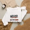 White hand-drawn crewneck sweatshirt with the welder dictionary joke: Hard to shop for. Already built it., folded view
