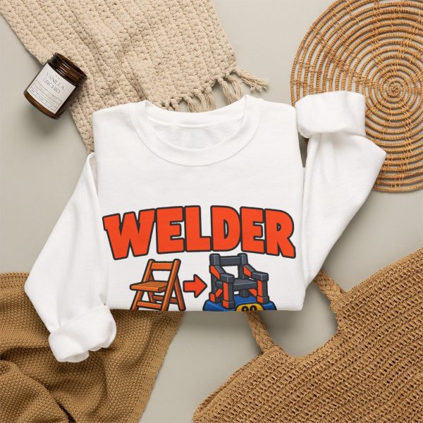 White crewneck sweatshirt printed with an orange and blue WELDER dictionary entry, "Hand them a $5 chair. It comes back weighing 90 pounds.", styled flat lay